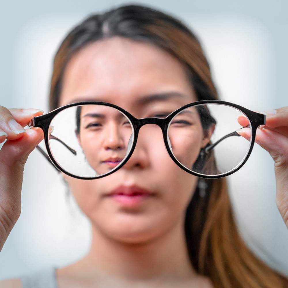 Artistic photo of a women through a pair of glasses