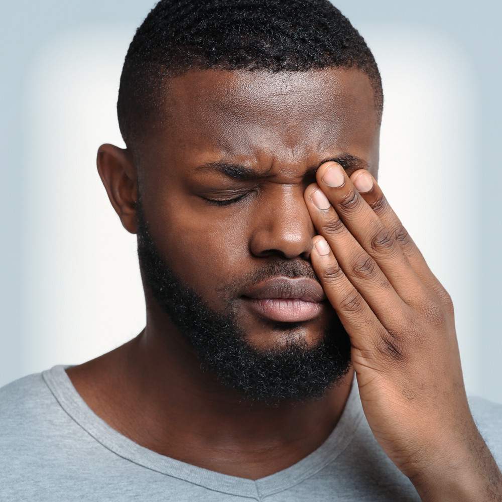 Man rubbing eyes showing irritability